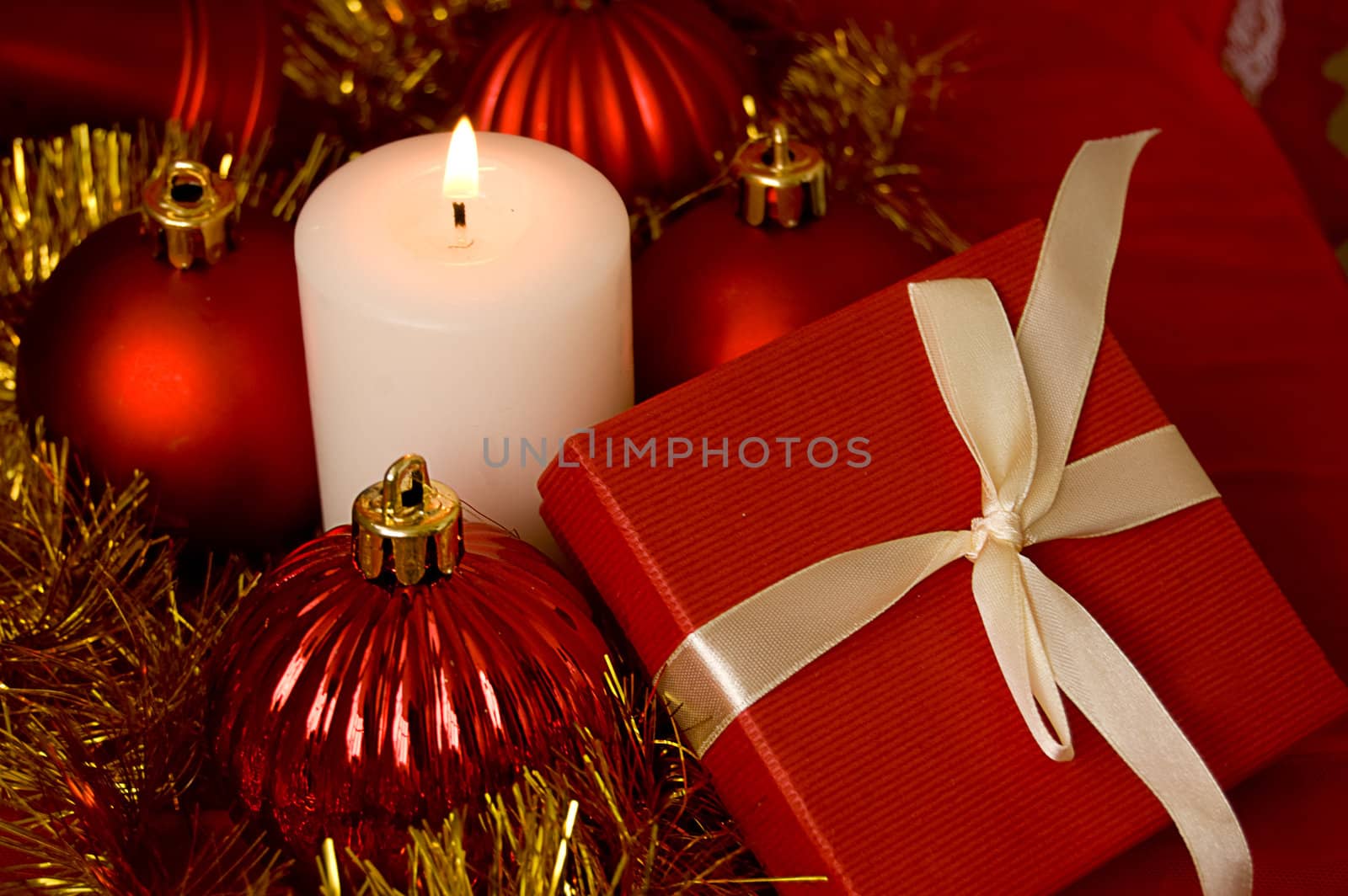 Red gift box and candle over Christmas background