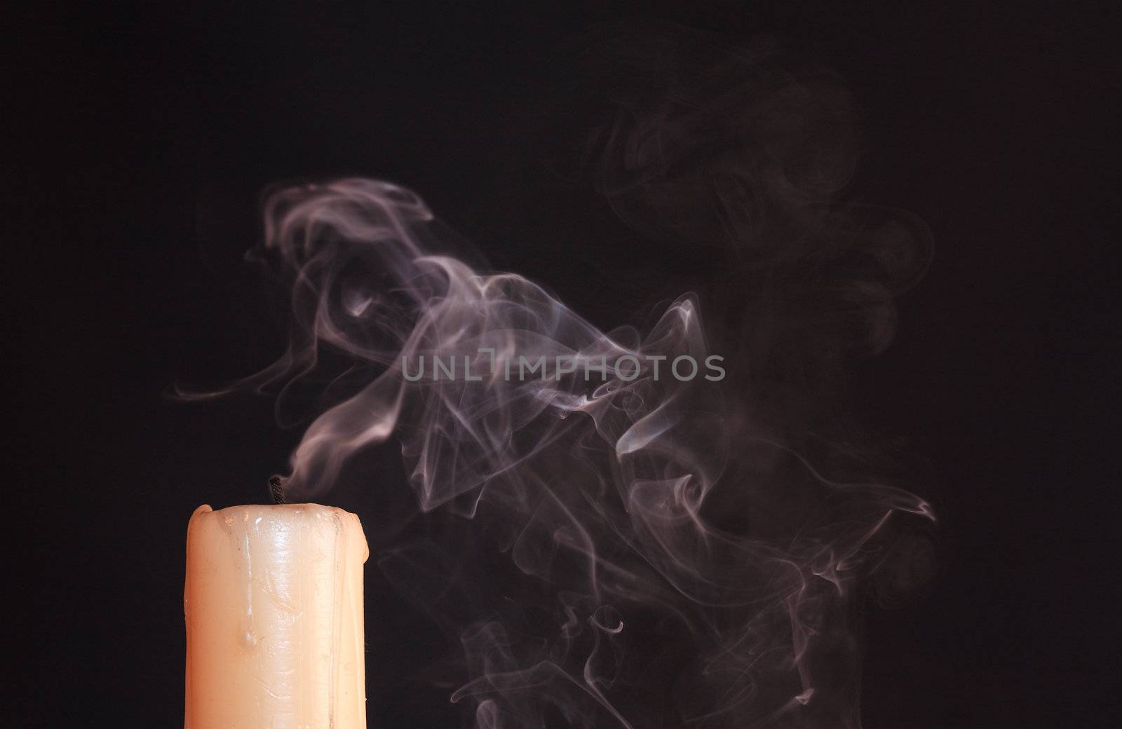 Extinguished  candle with smoke on black background with copy space