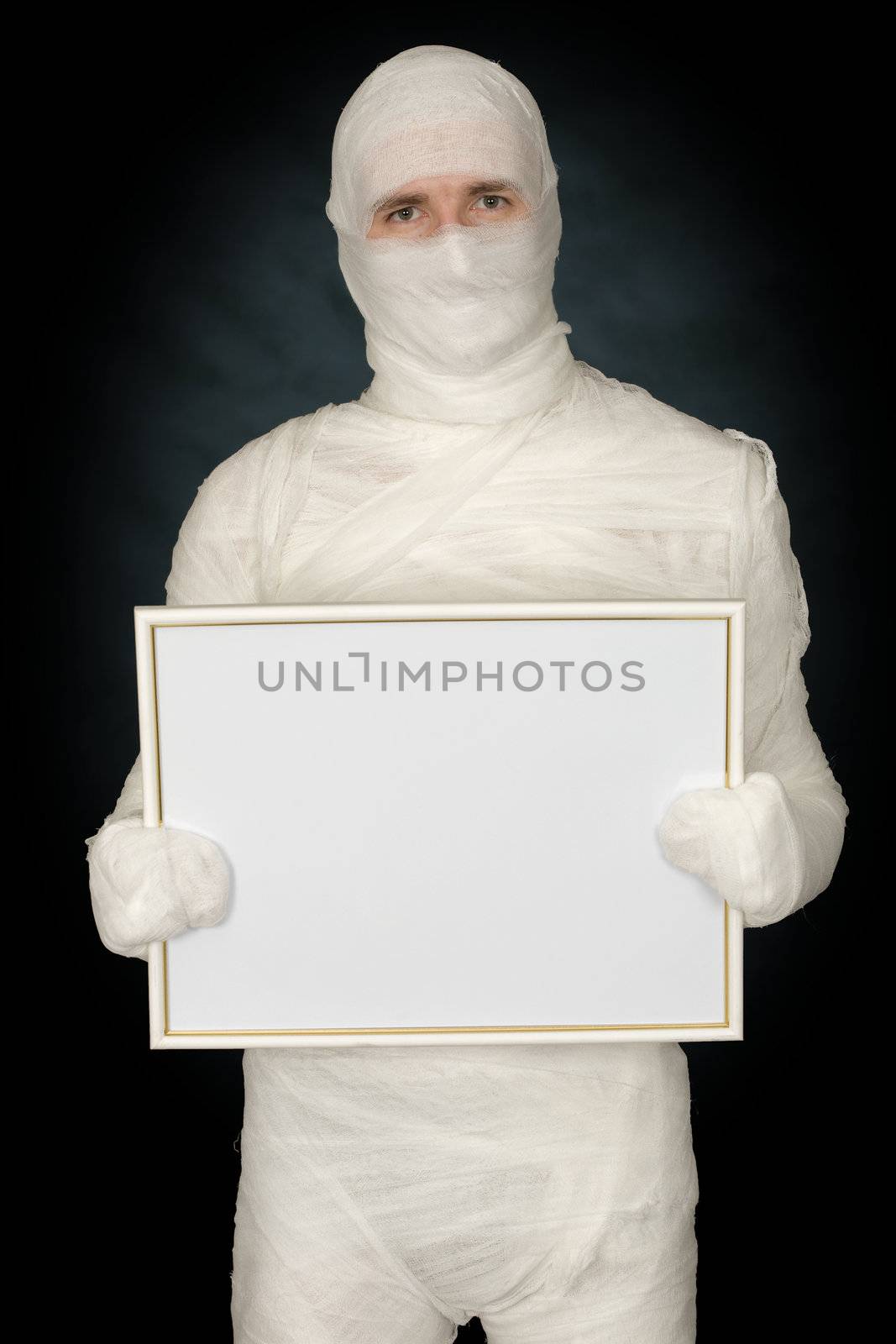 Mummy with blank frame on the black background