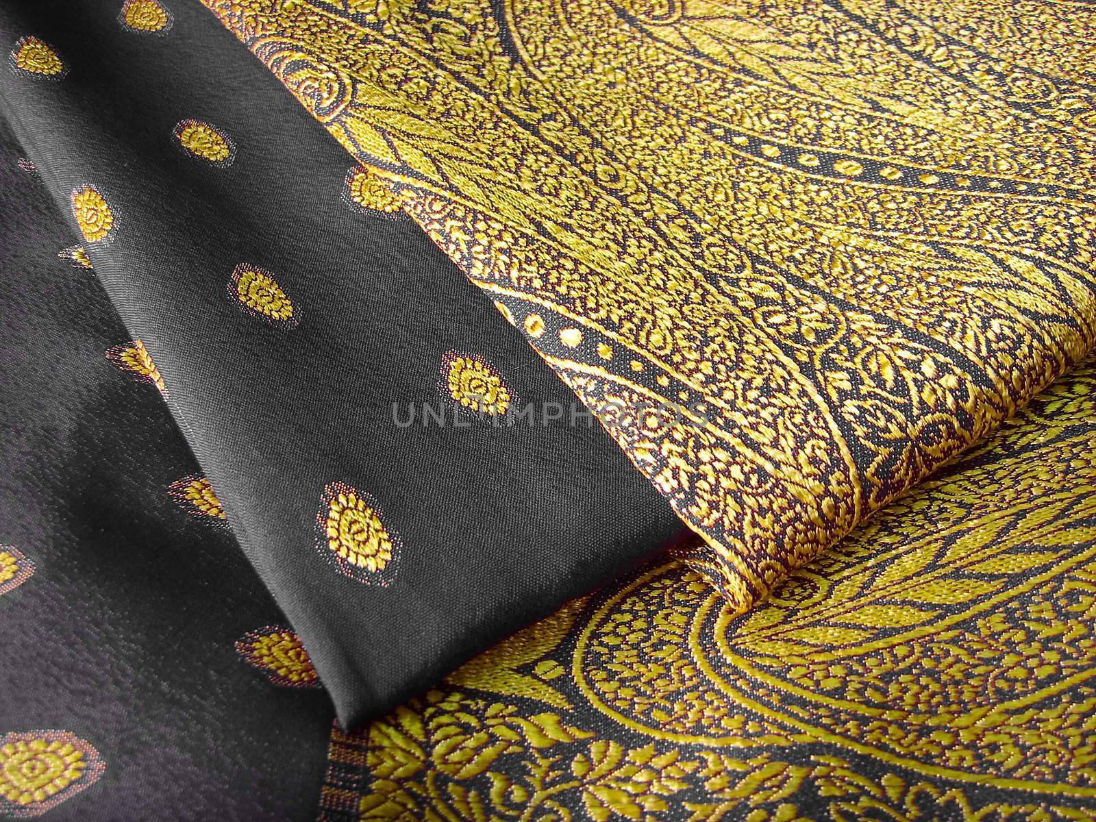 A folded black and yellow saree with floral designs
