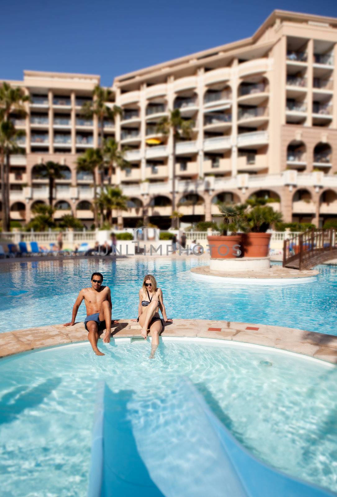 A man and woman enjoying a hotel pool with waterslide