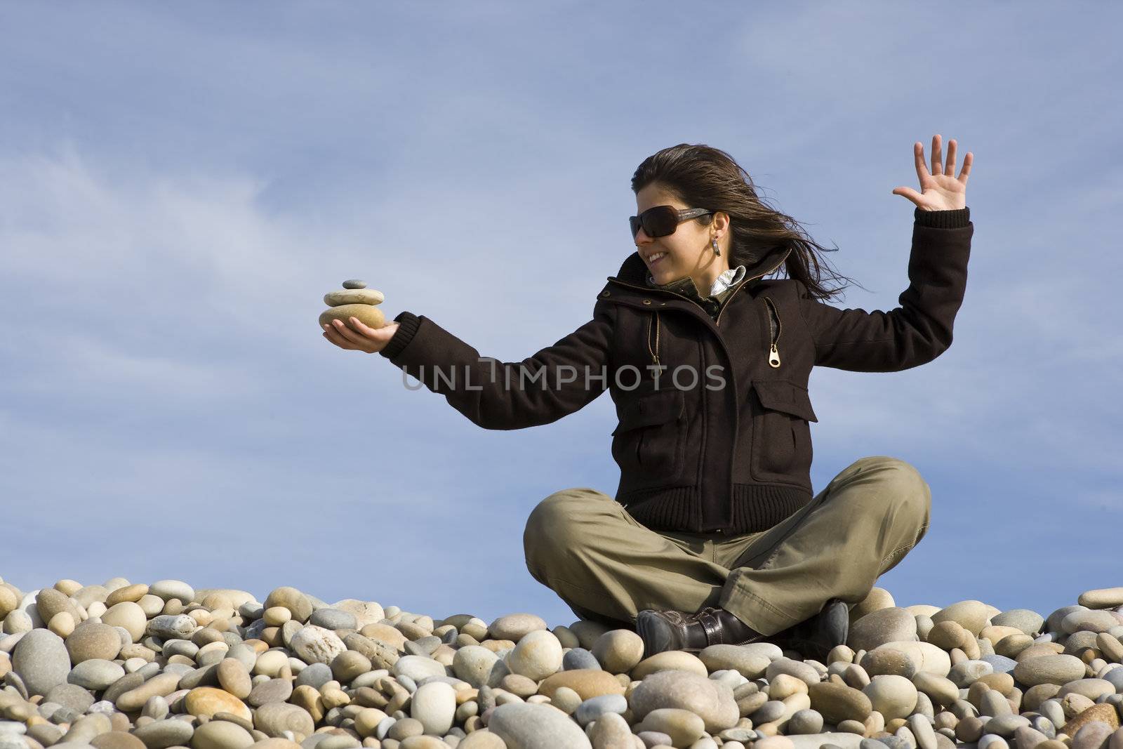 young casual woman holding pile of round stones in the hand