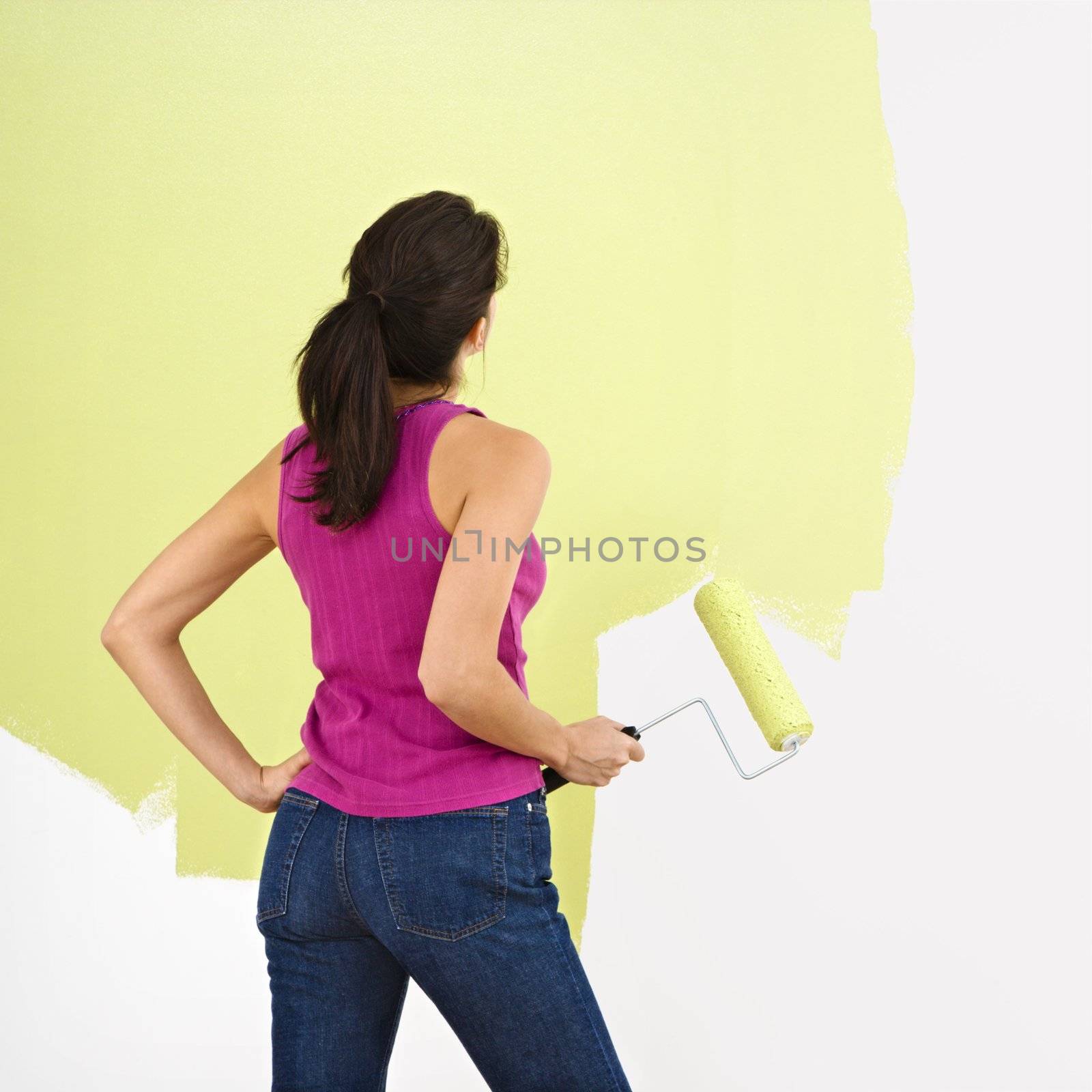 Woman painting wall. by iofoto