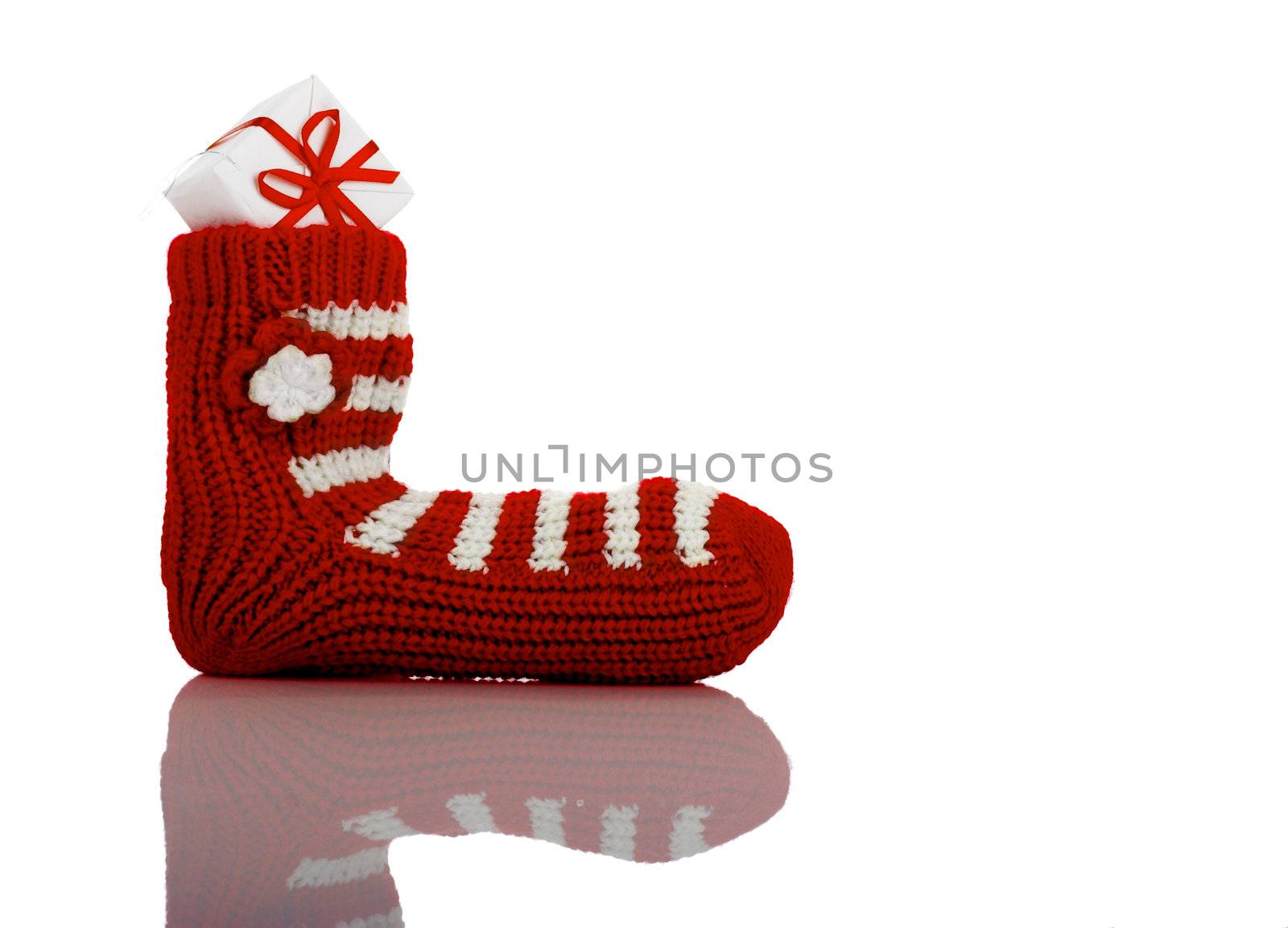 A red Christmas Sock with gift isolated on white background with reflection
