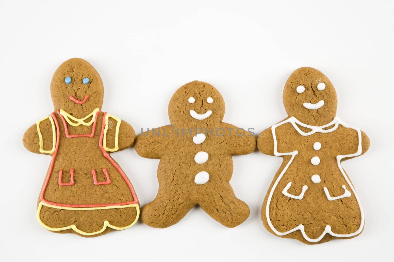 Three male and female gingerbread cookies holding hands.