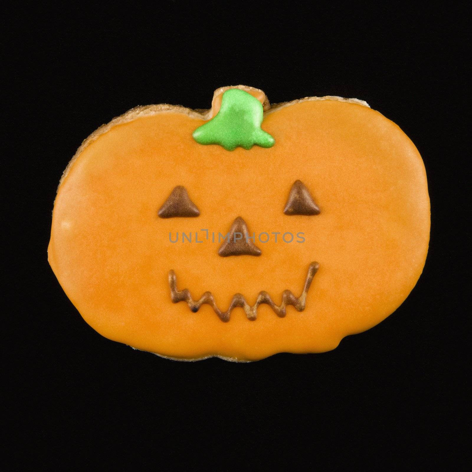 Sugar cookie in shape of pumpkin with decorative icing.