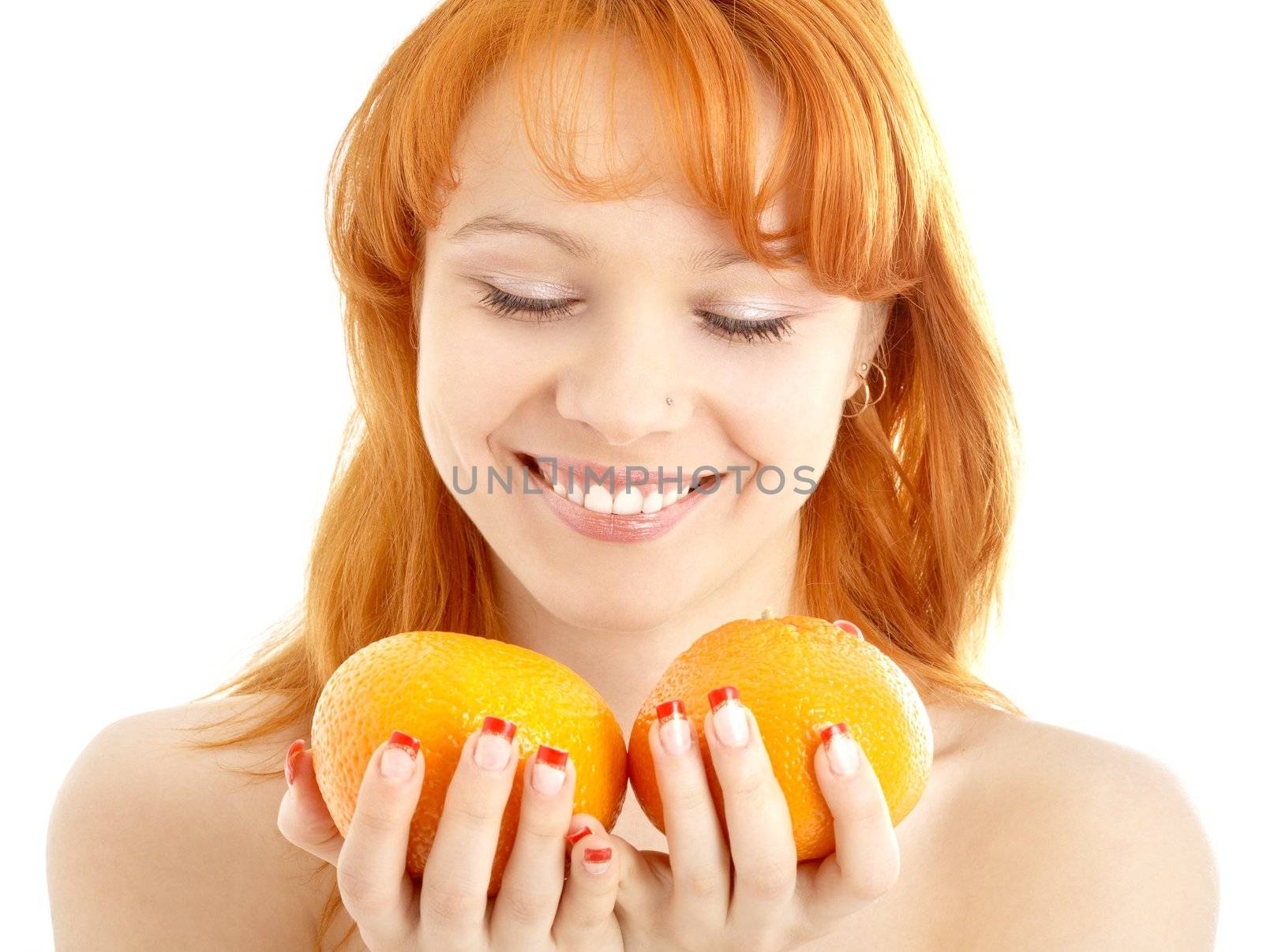 picture of cheerful redhead holding two oranges over white