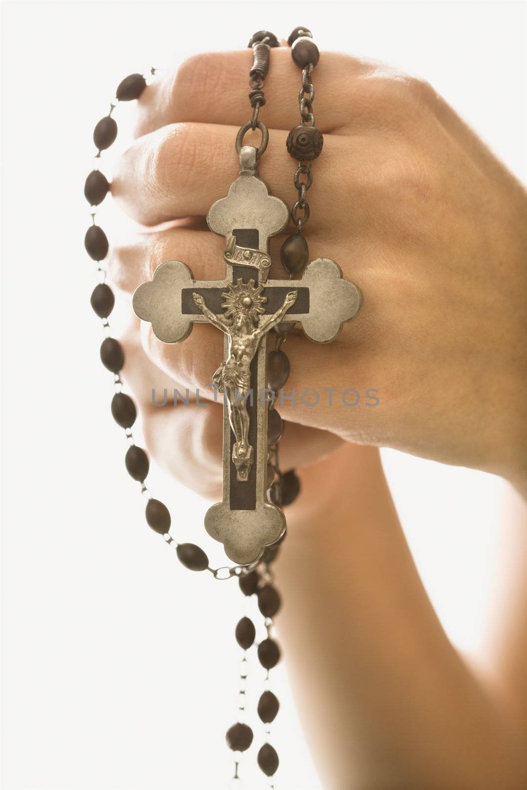 Woman's hands holding rosary with crucifix.