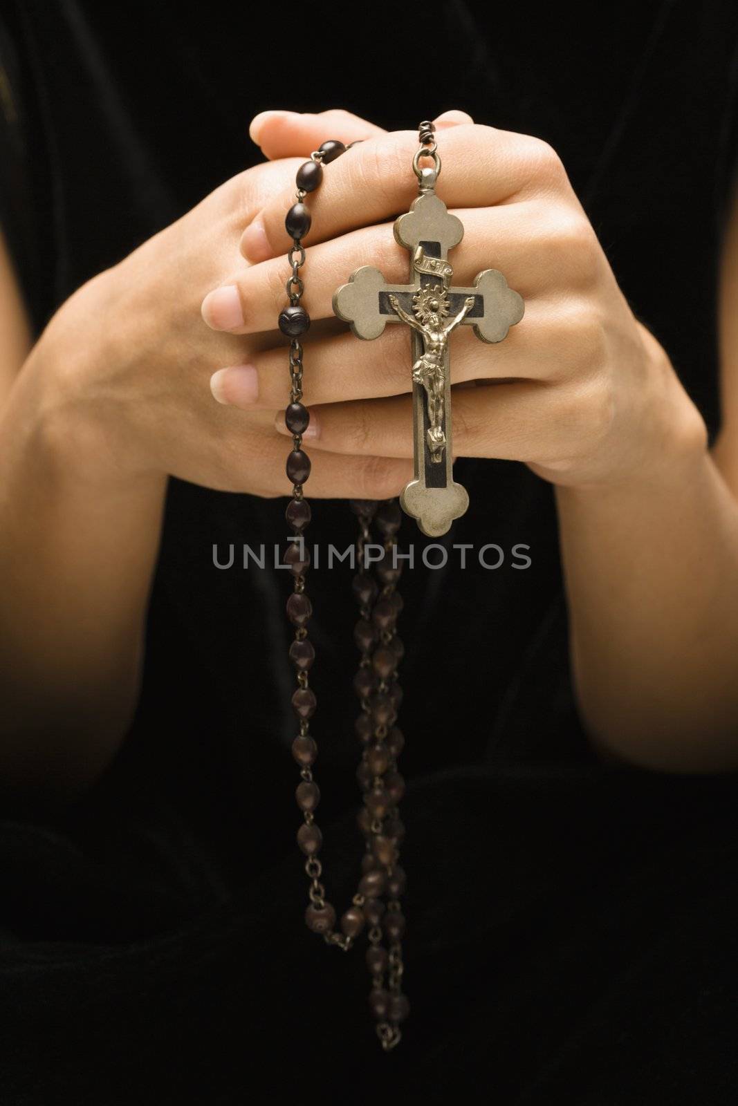 Woman holding rosary with crucifix.