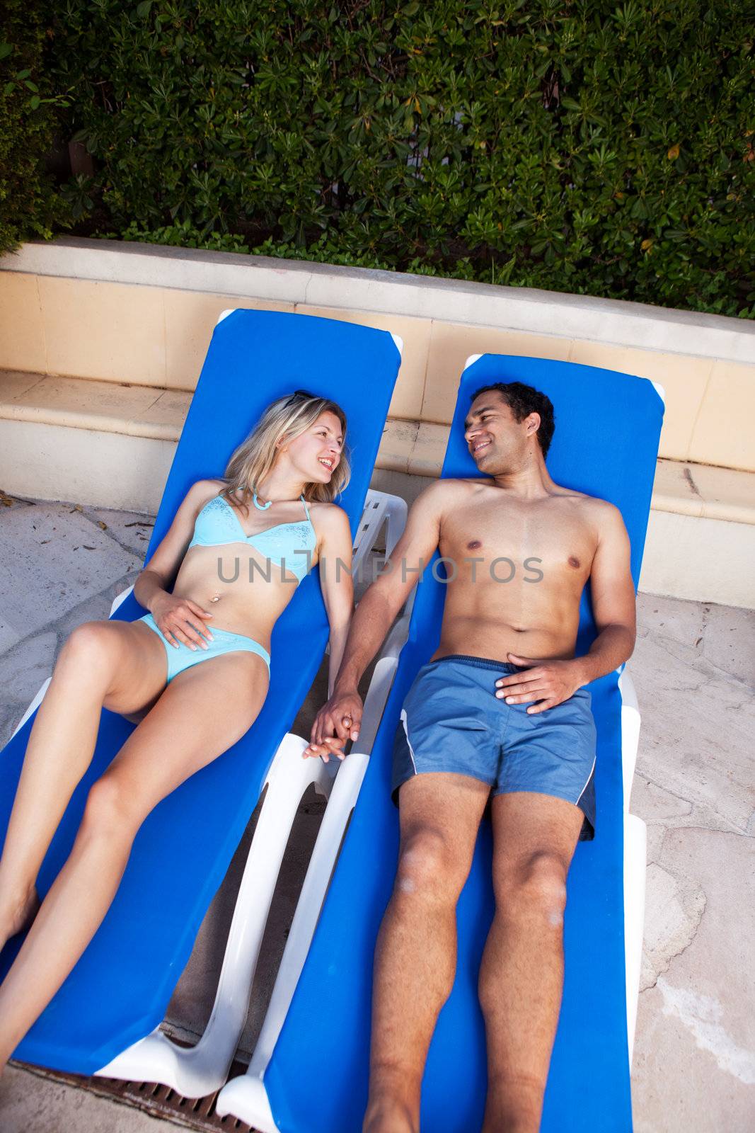 A couple on a holiday sitting by a pool