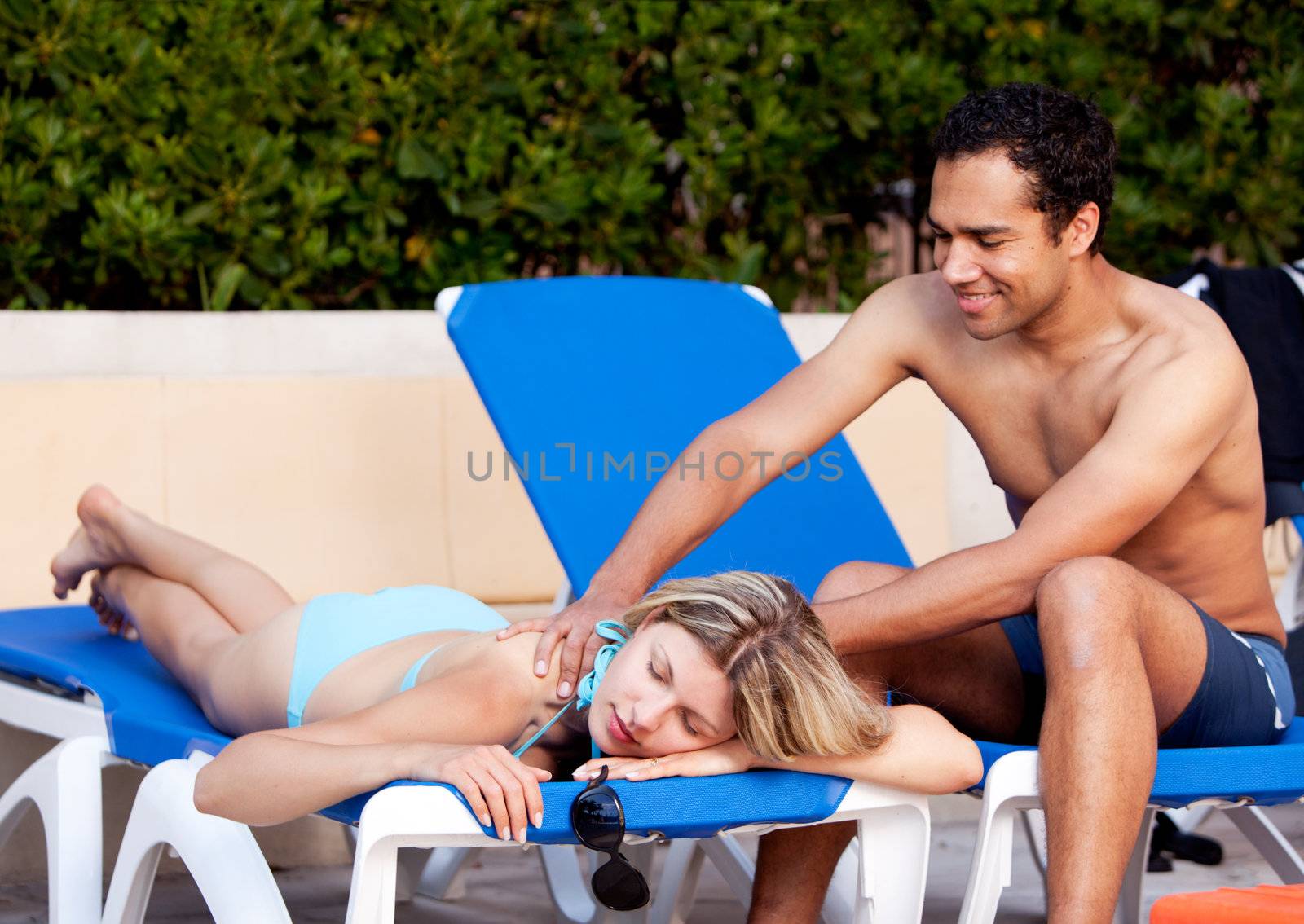 A woman receiving a back massage on a pool chair