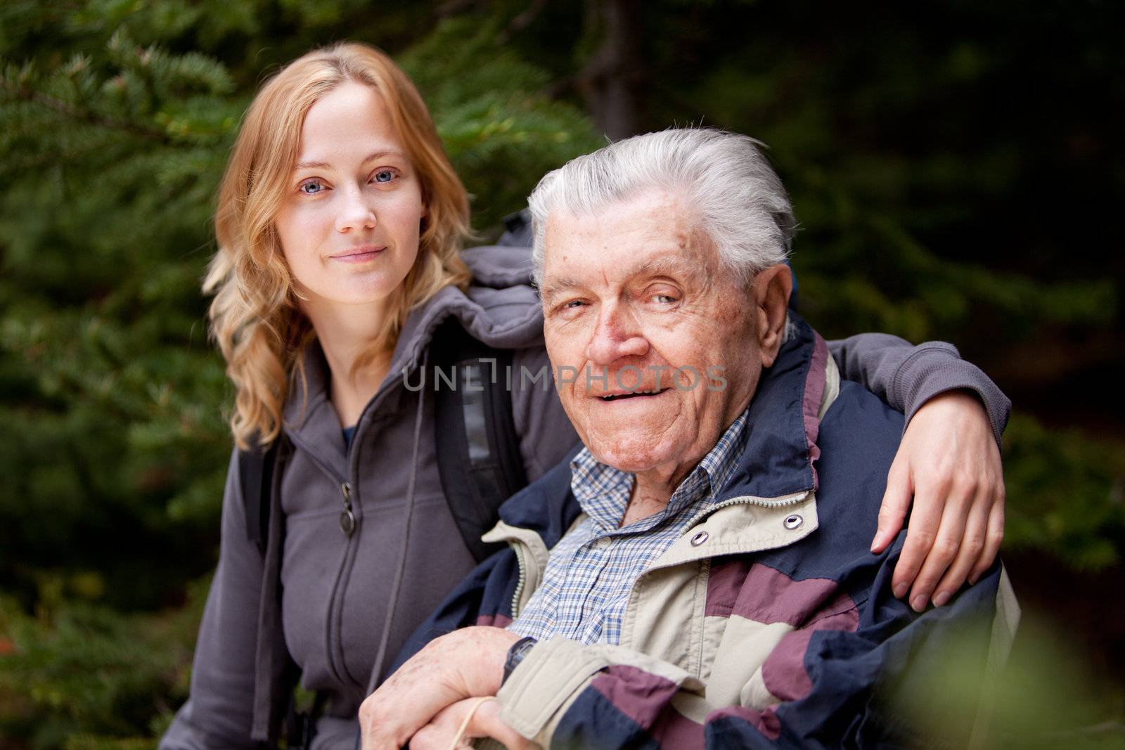 A portrait of a granddaughter with her grandfather in the forest