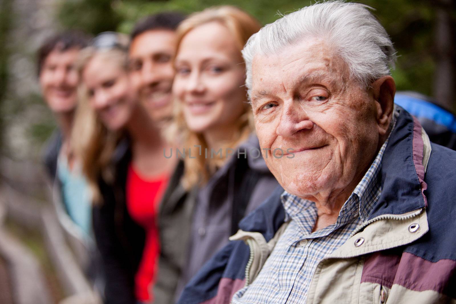 An elderly man in front of a group of young people