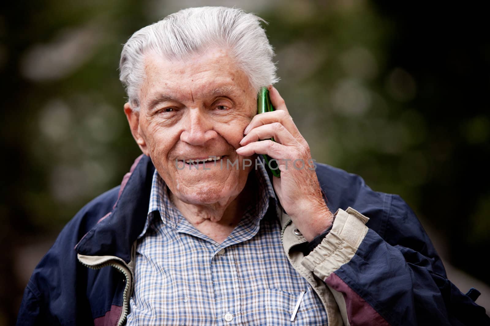 A portrait of a senior using a cell phone outdoors