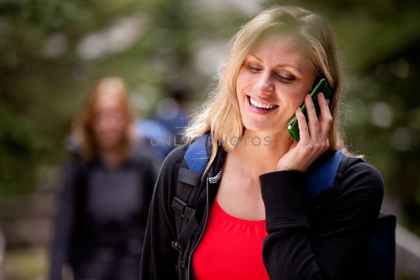 A happy woman talking on a cell phone outdoors