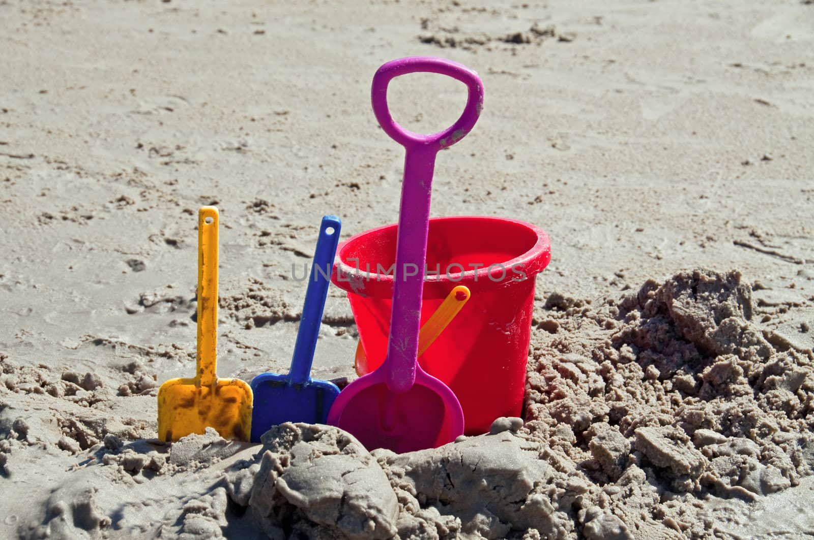 Toy shovels and bucket in use on a beach