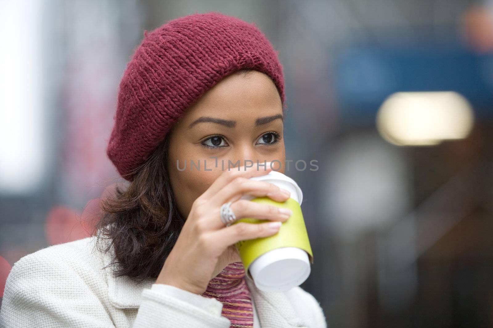 An attractive business woman enjoying a hot coffee in the city.