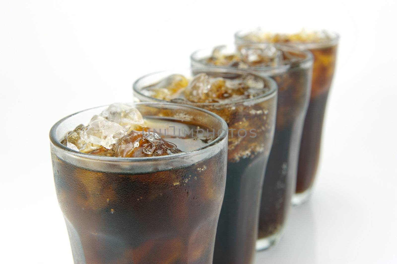 Glasses of cola isolated against a white background