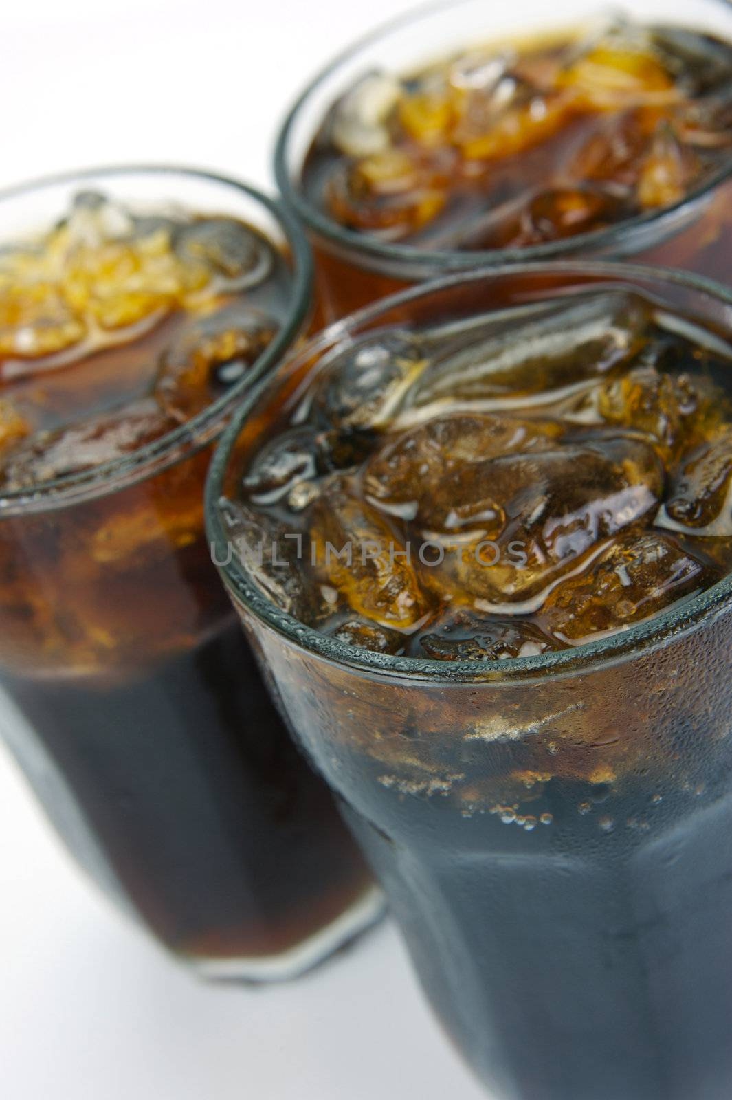 Glasses of cola isolated against a white background