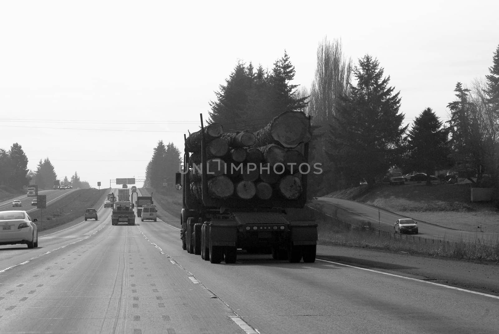 Logging truck fully loaded on Oregon Freeway, black and white, horizontal