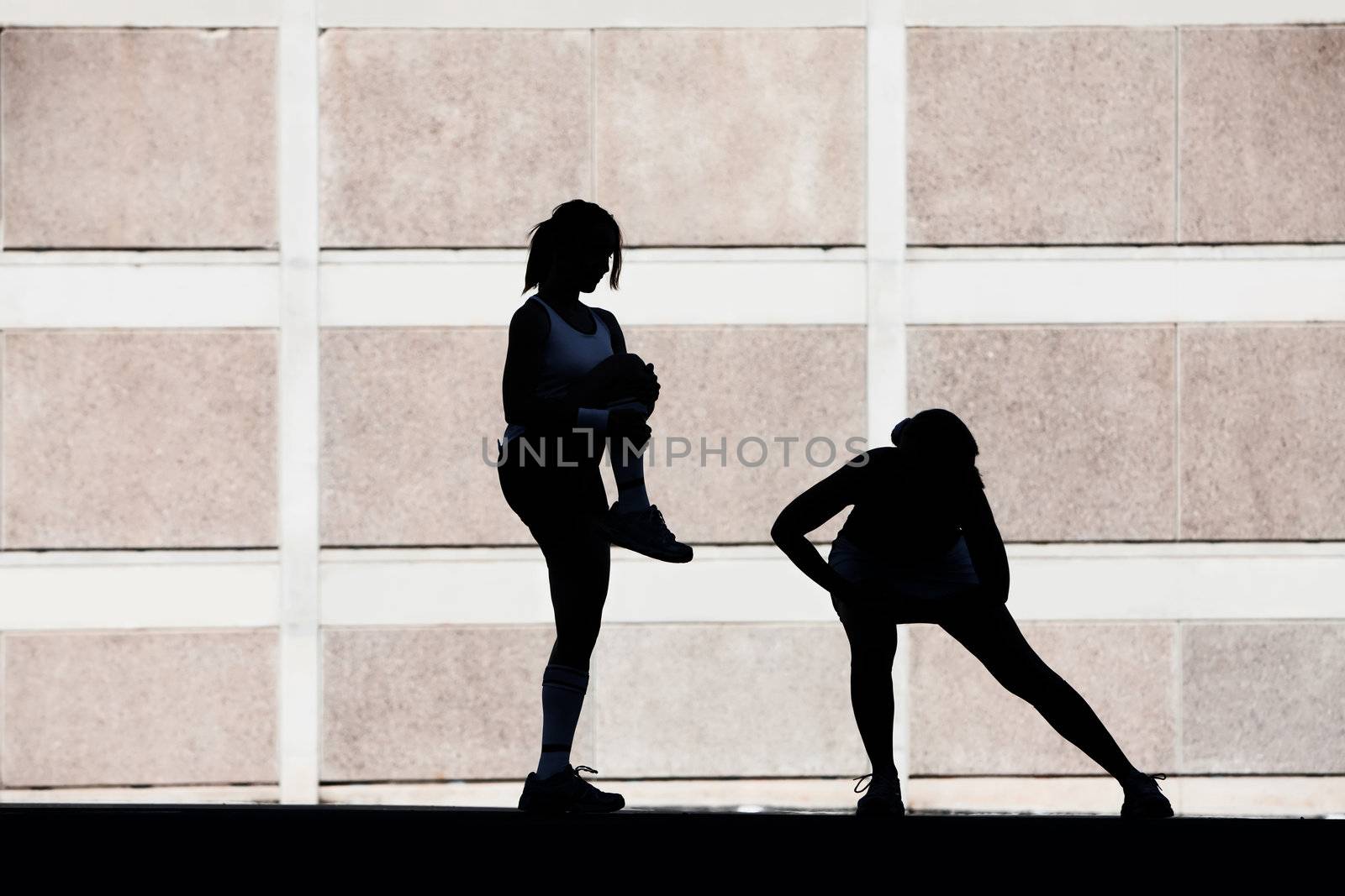 Two female friends stretching before a run.