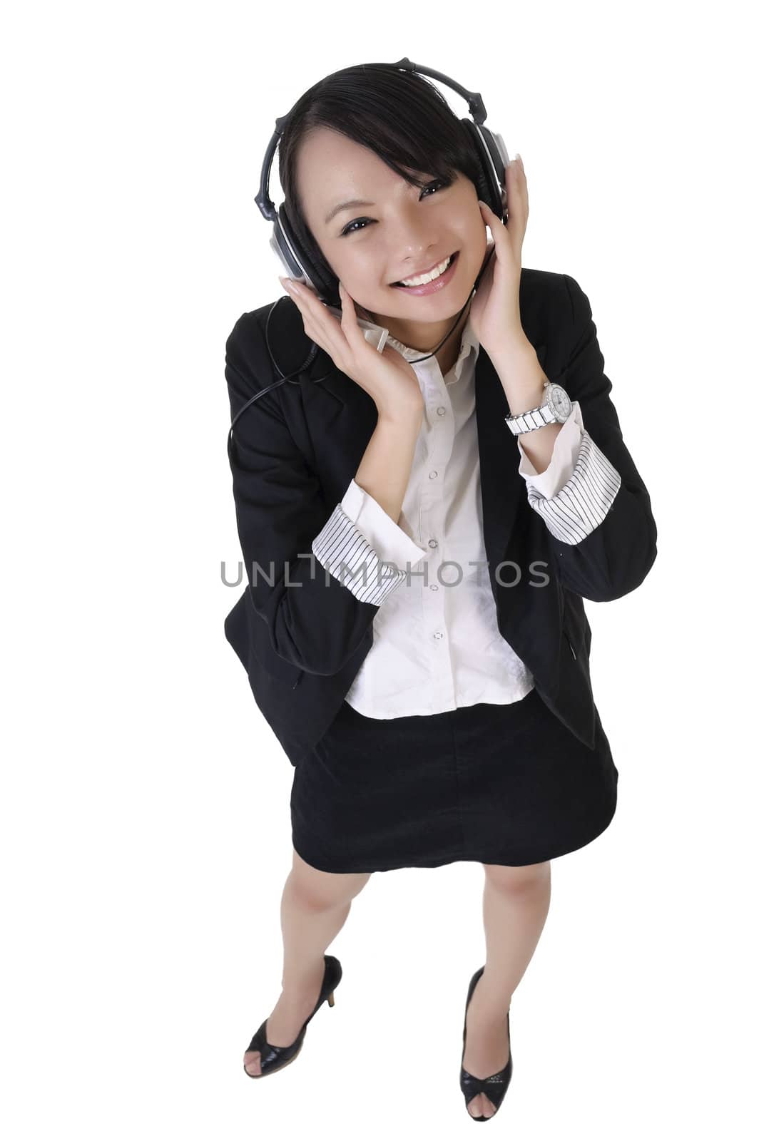 Happy smiling business woman listen music by headphone, full length portrait isolated on white background.