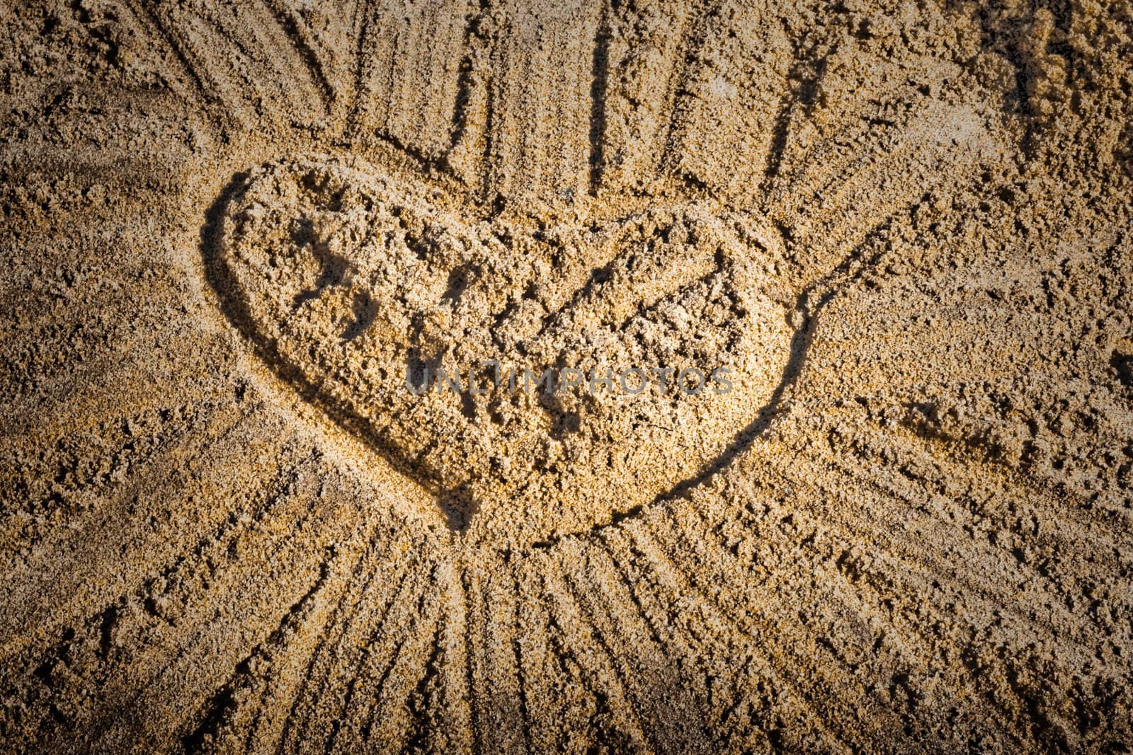 lovely heart with rays  on beach sand