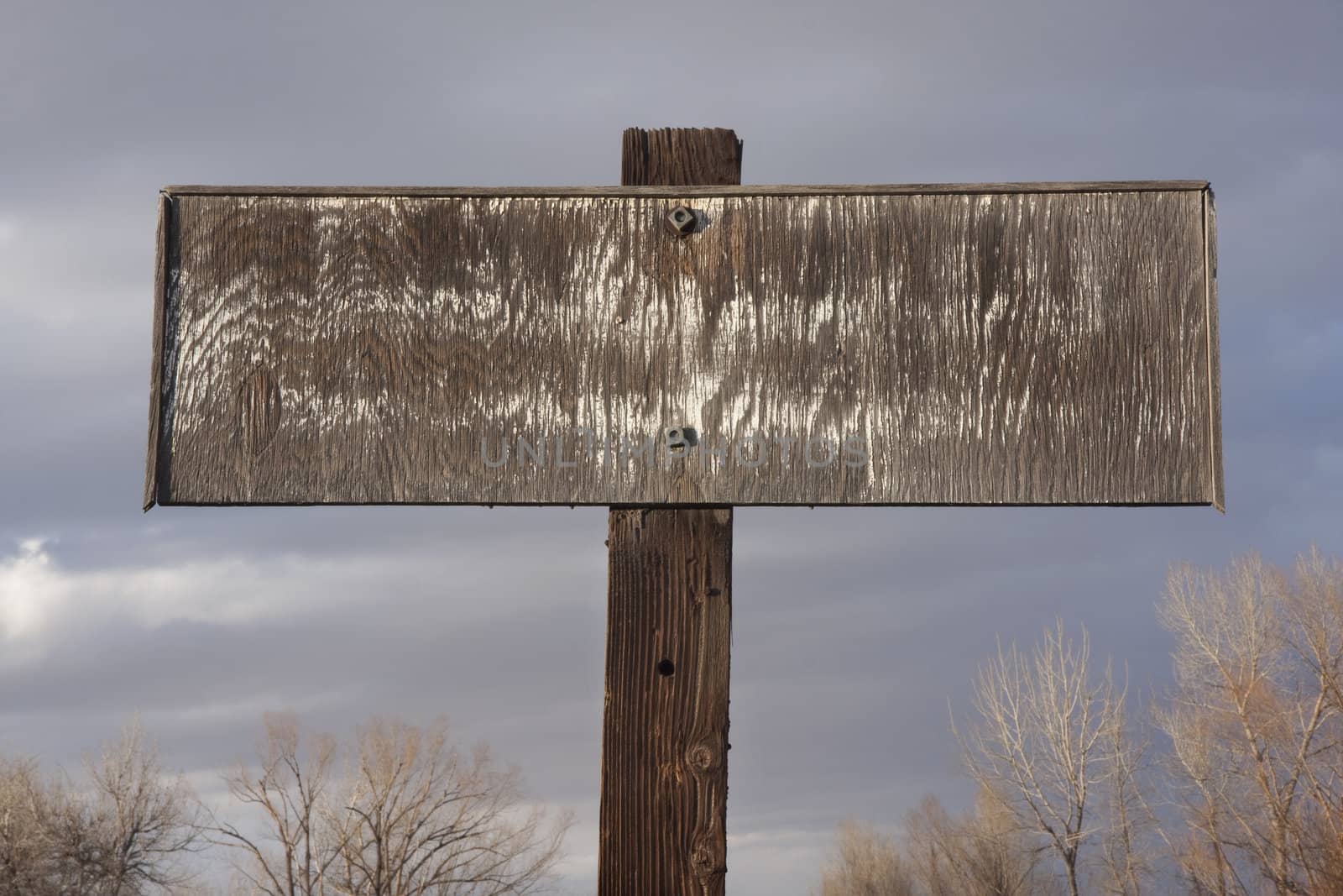 old faded rectangular plywood private propery sign against cloudy sky