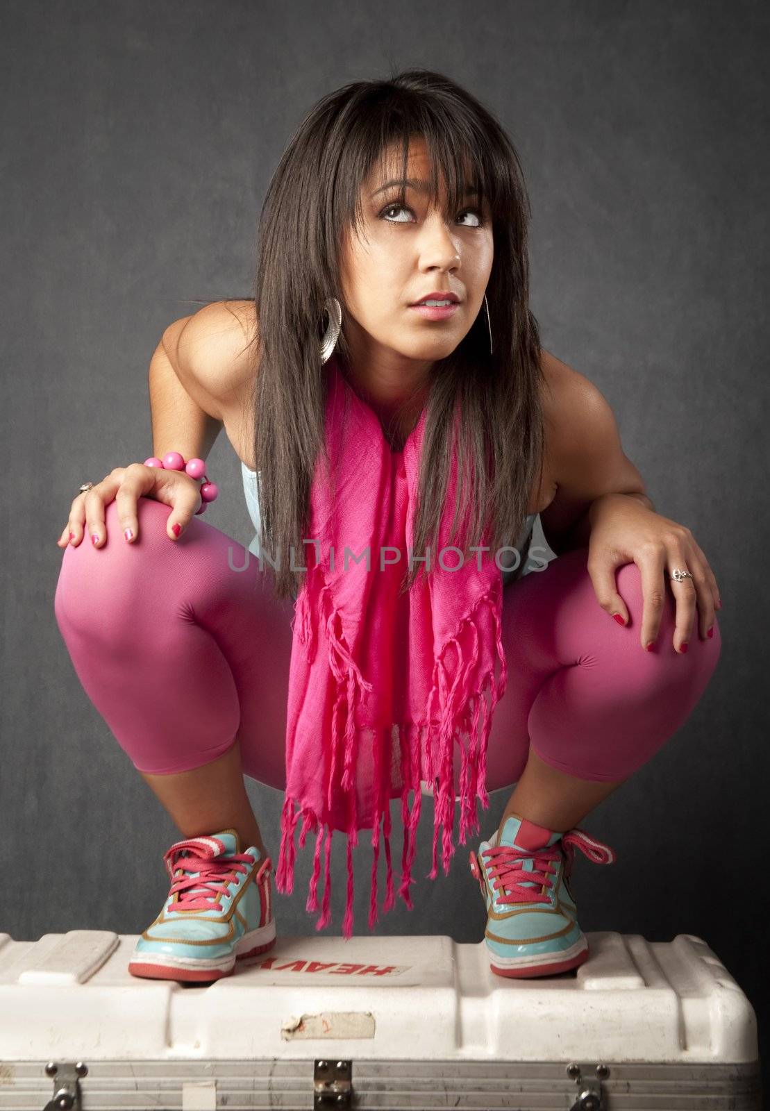 Pretty young mixed race woman crouched on a cargo box