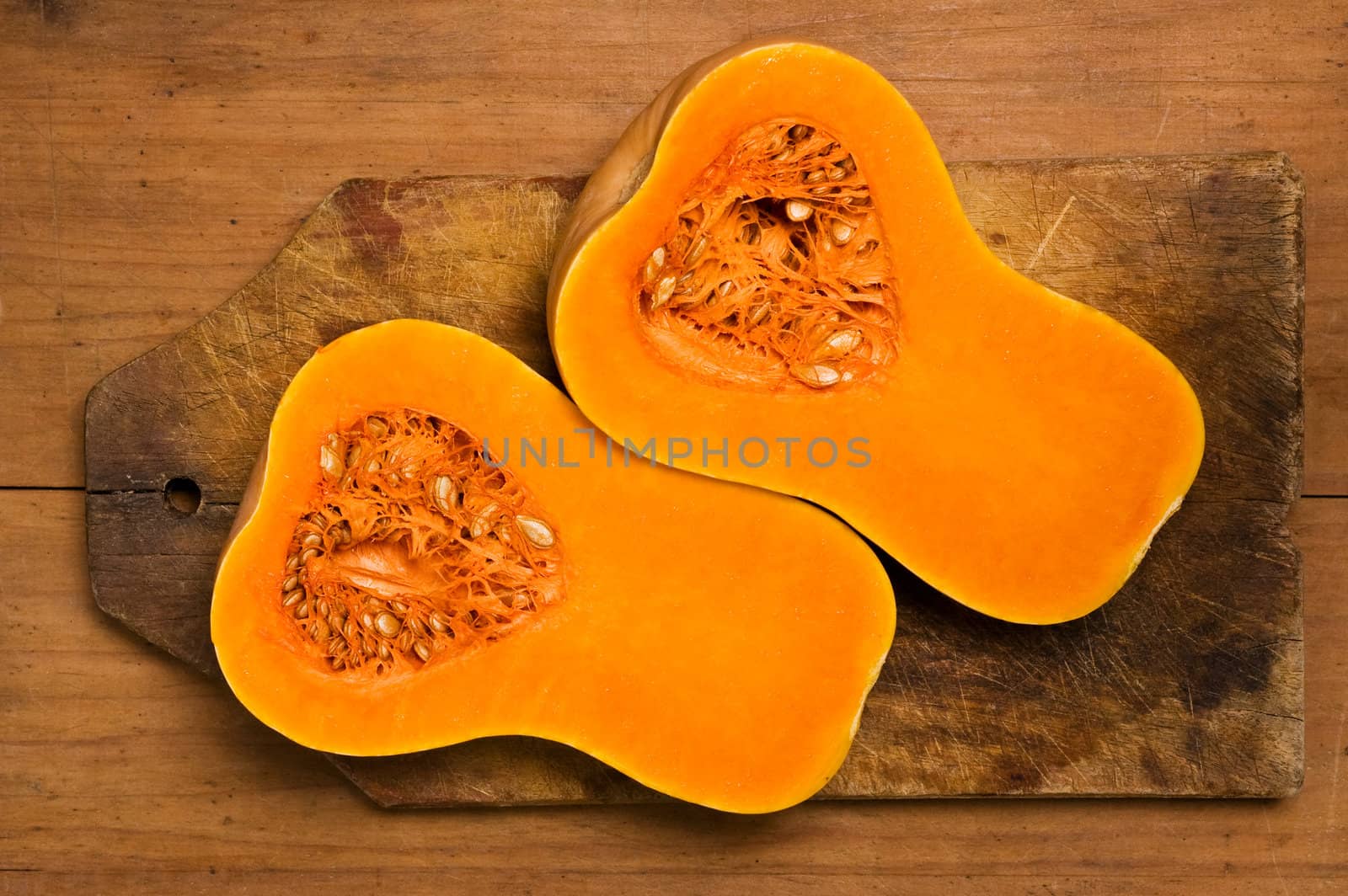 Two slices of pumpkin on a wooden kitchen table.