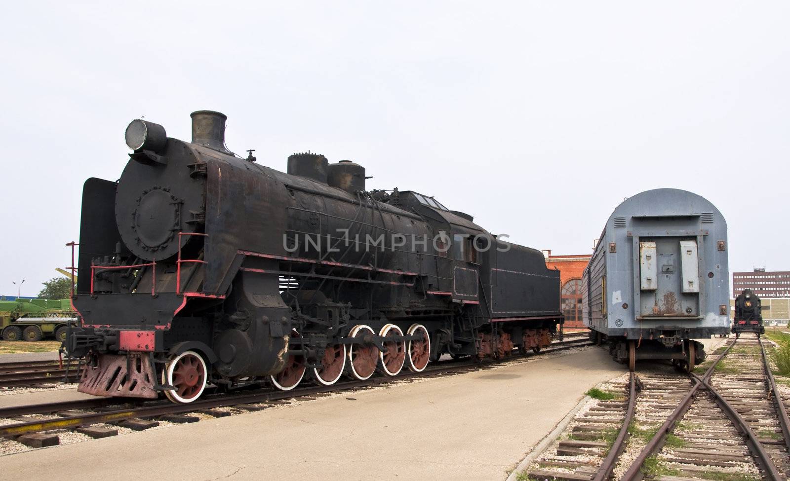 Steam locomotive beside a railway station platform. Retro train.