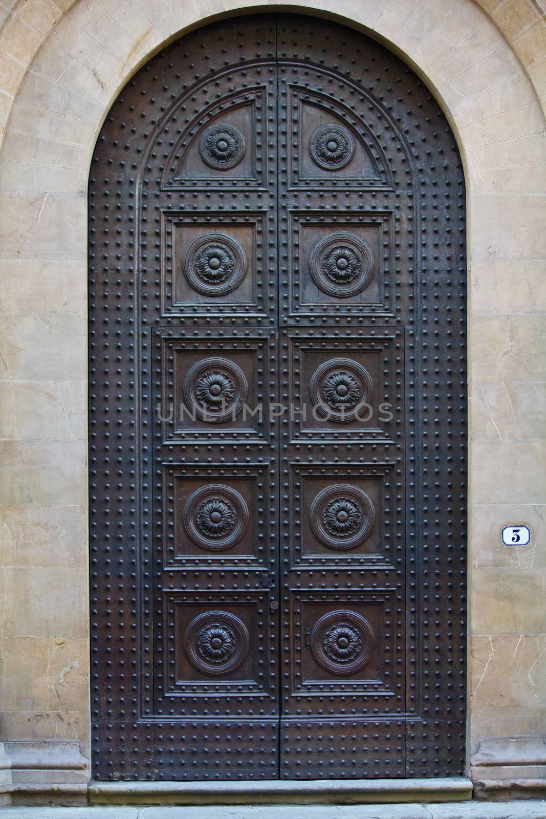 Old wooden door with a lot of iron nails in Tuscany / Italy