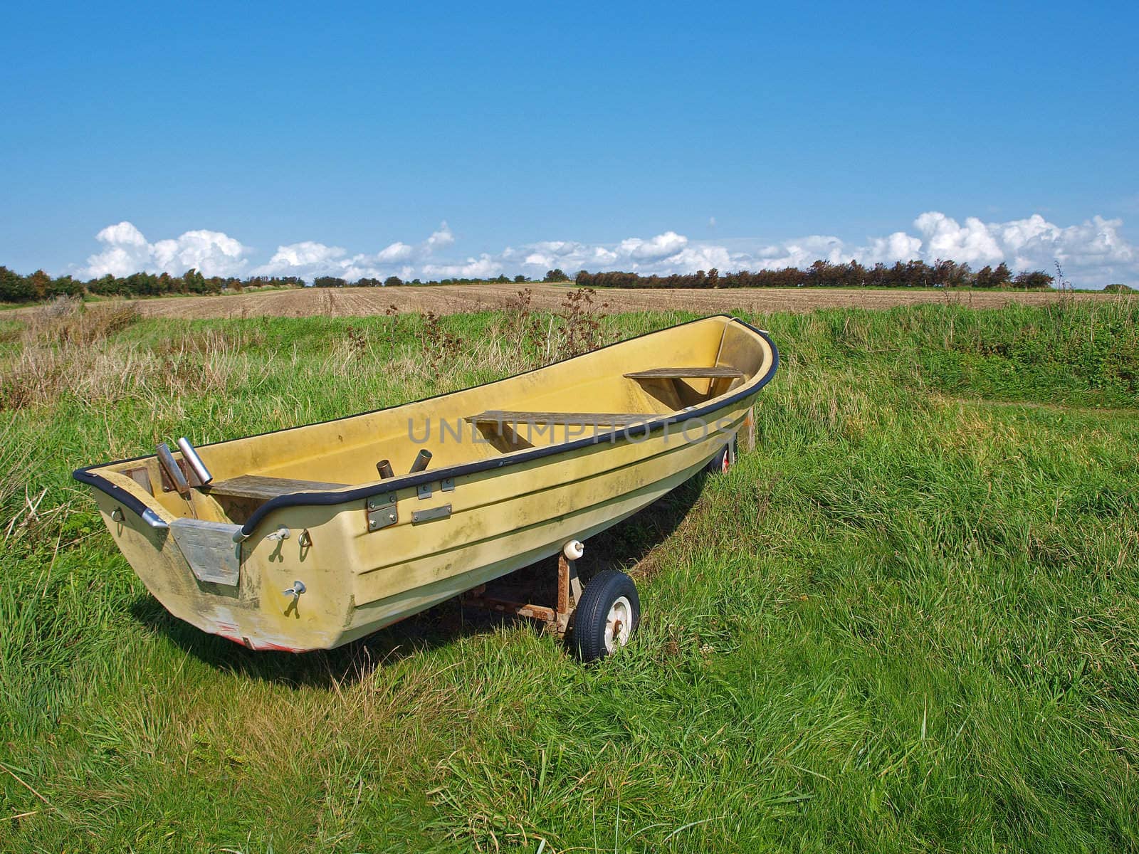 Small fishing Skiff boat on the seashore green field