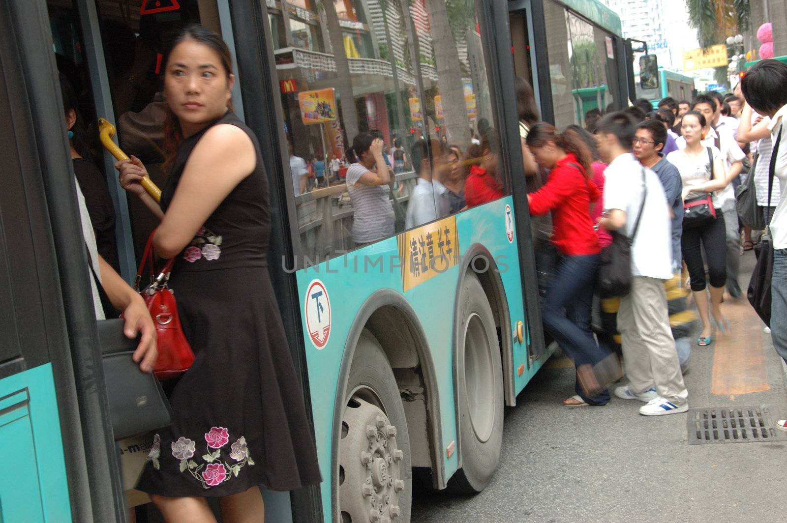 CHINA, SHENZHEN - AUGUST 20: overpopulated city in Guangdong province. Crowd of people waits in queue and pushes to the buses after work.