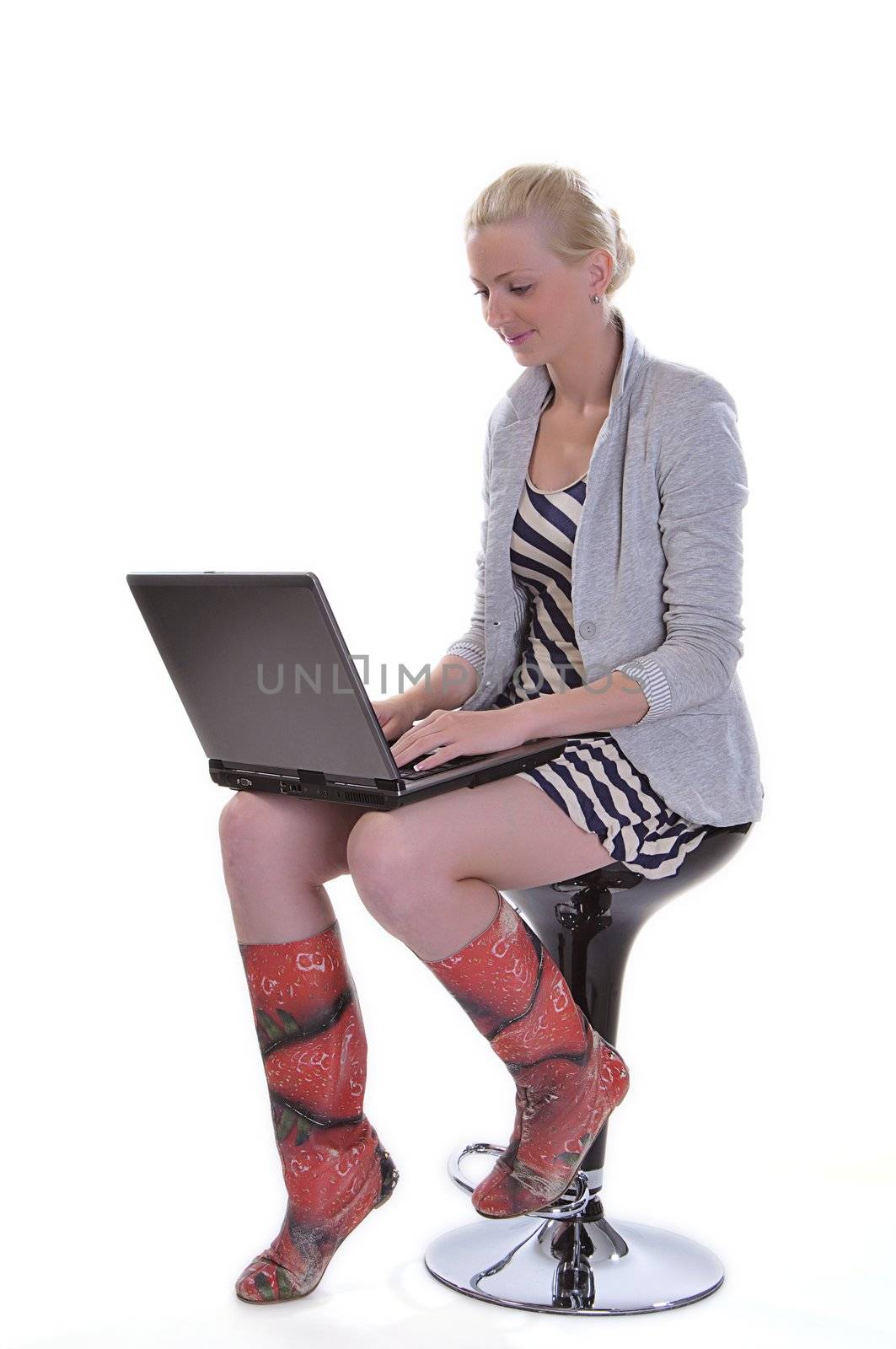 Beauty woman sits with a laptop on knees isolated on white