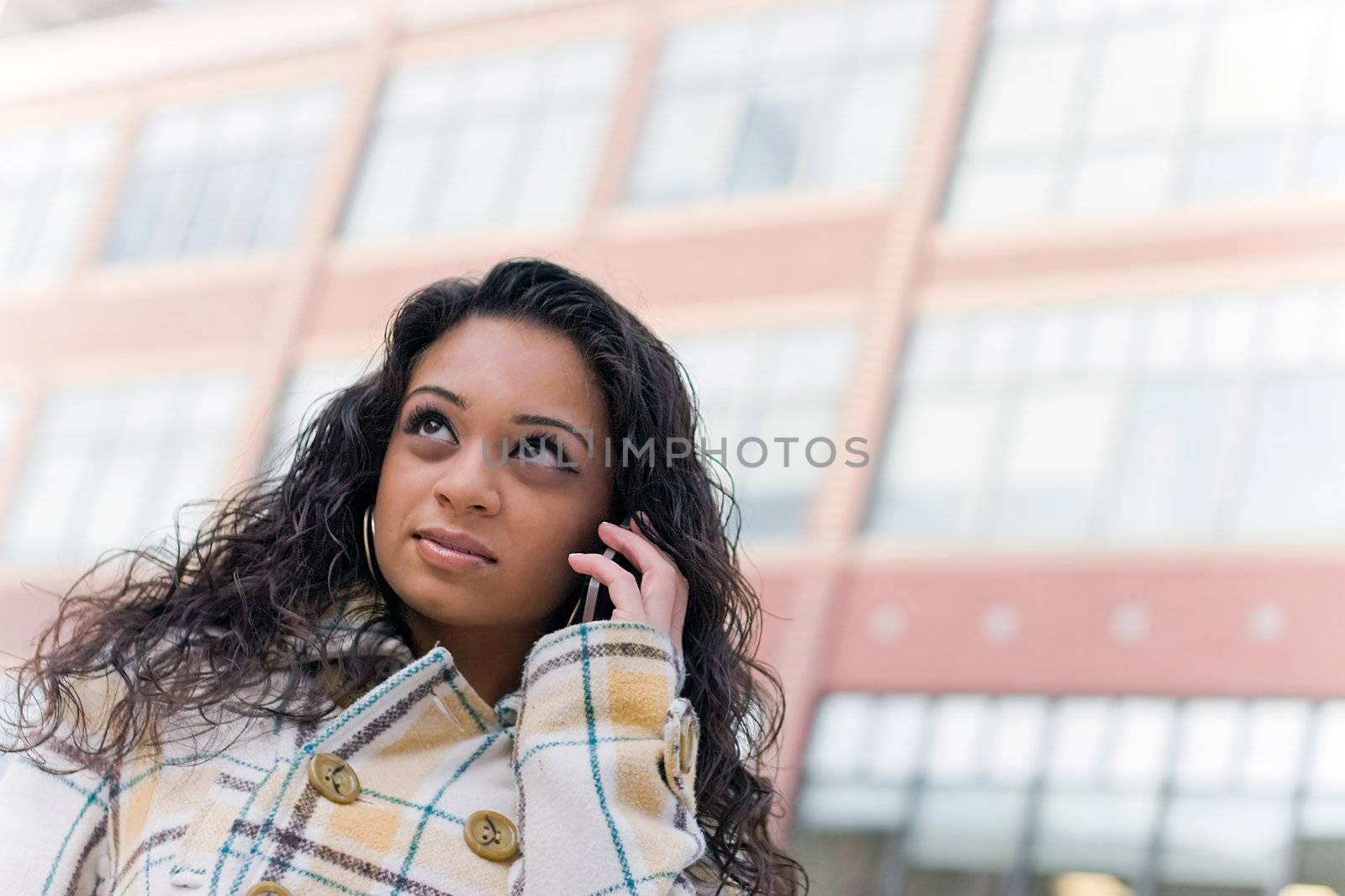 An attractive Indian woman talking on her cell phone in the city.