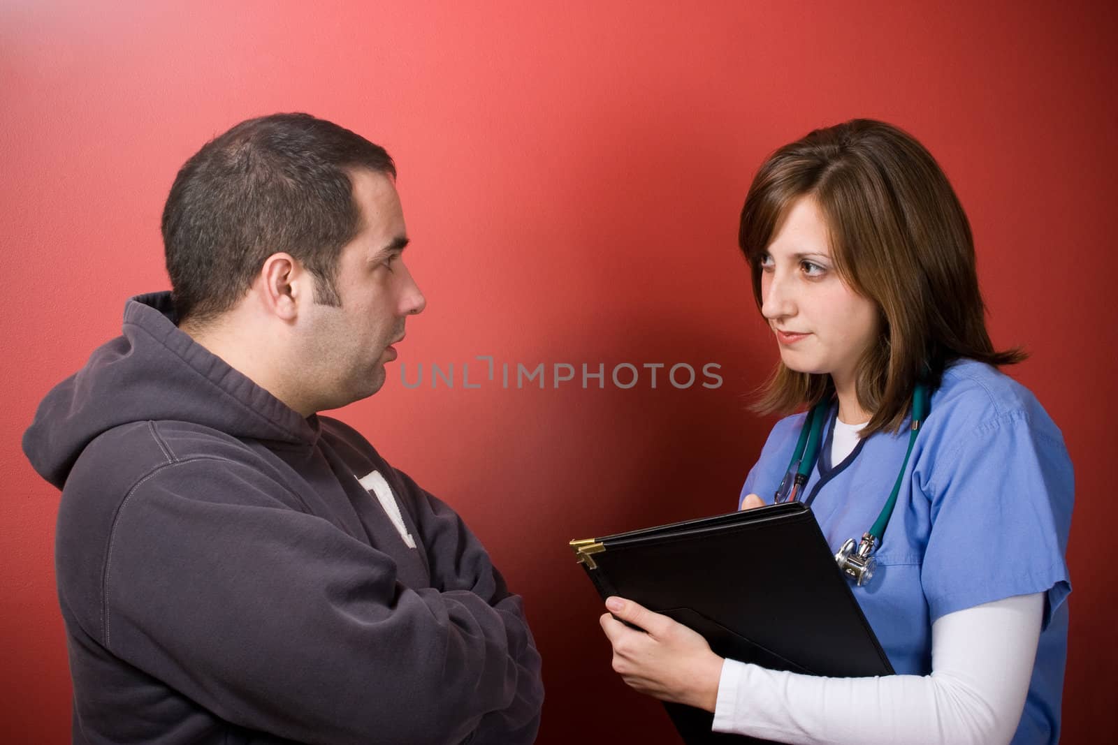 A young nurse talks to a patient during his visit.