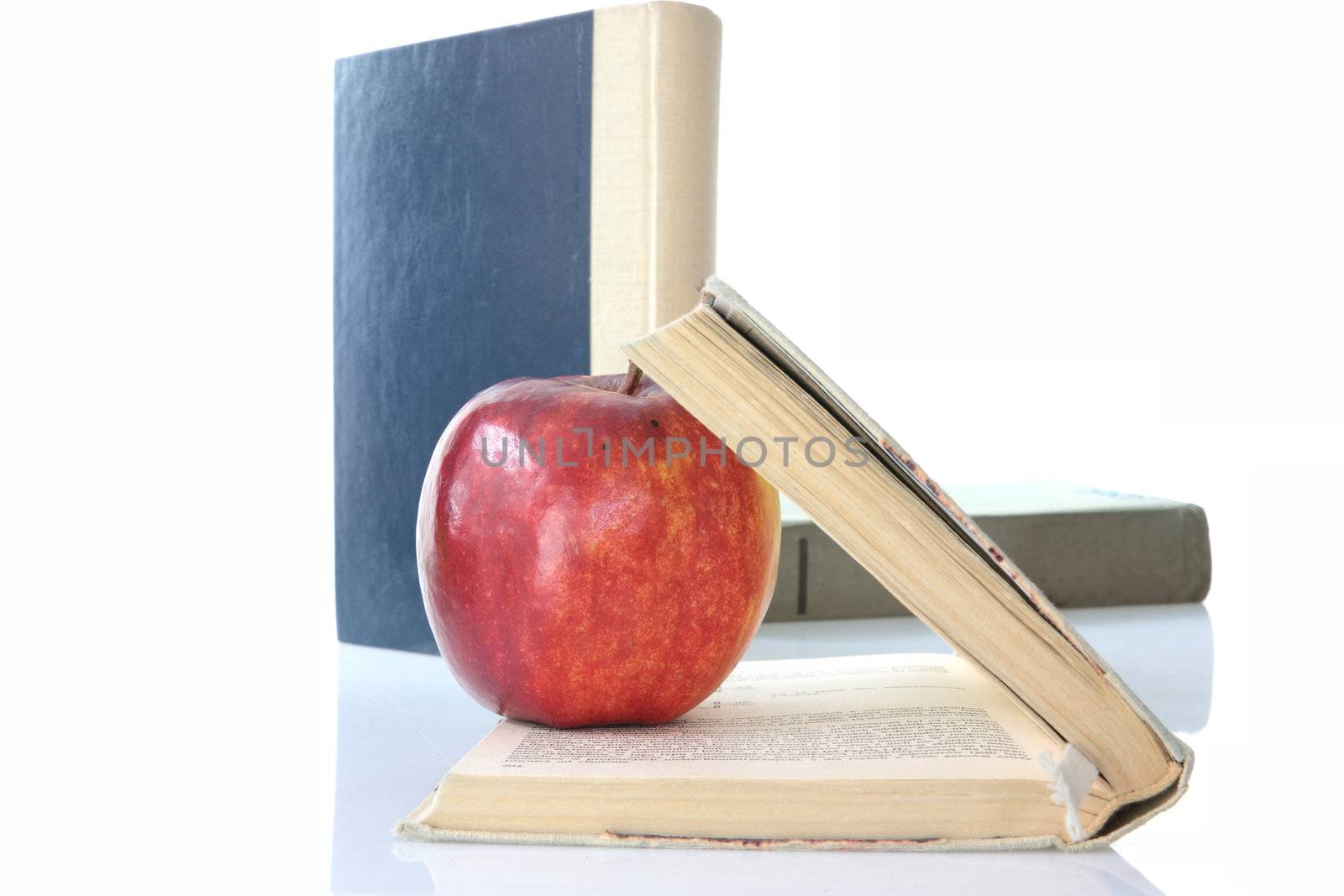 Red apple on books isolated on white