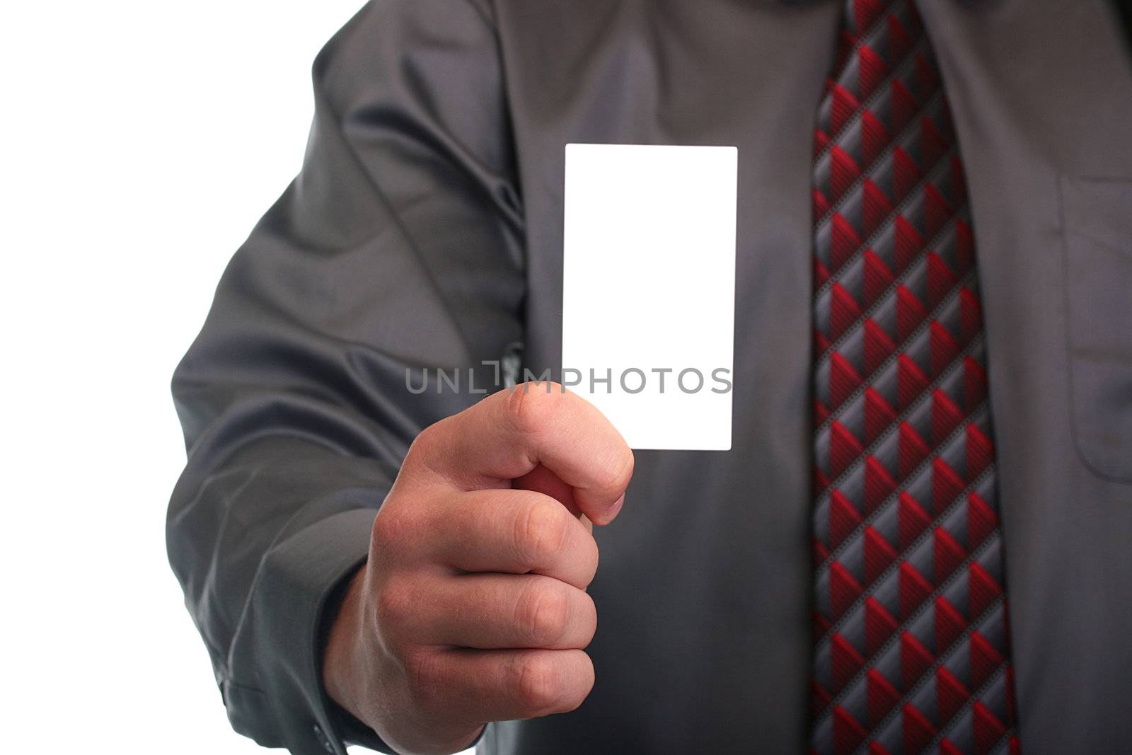 The businessman in a grey shirt and a tie stretches out a business card.