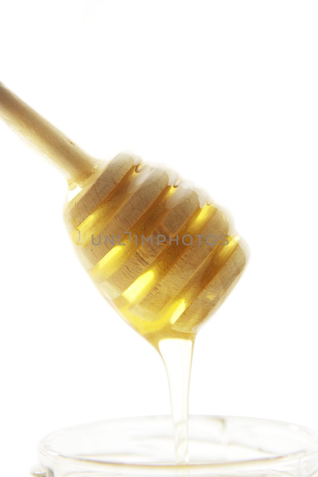 Wooden honey drizzler with a honey isolated on white.