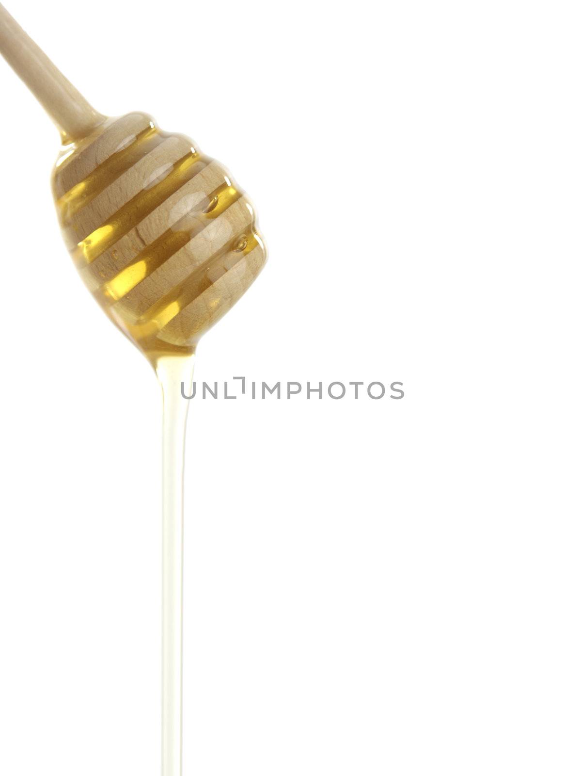 Wooden honey drizzler with a honey isolated on white.