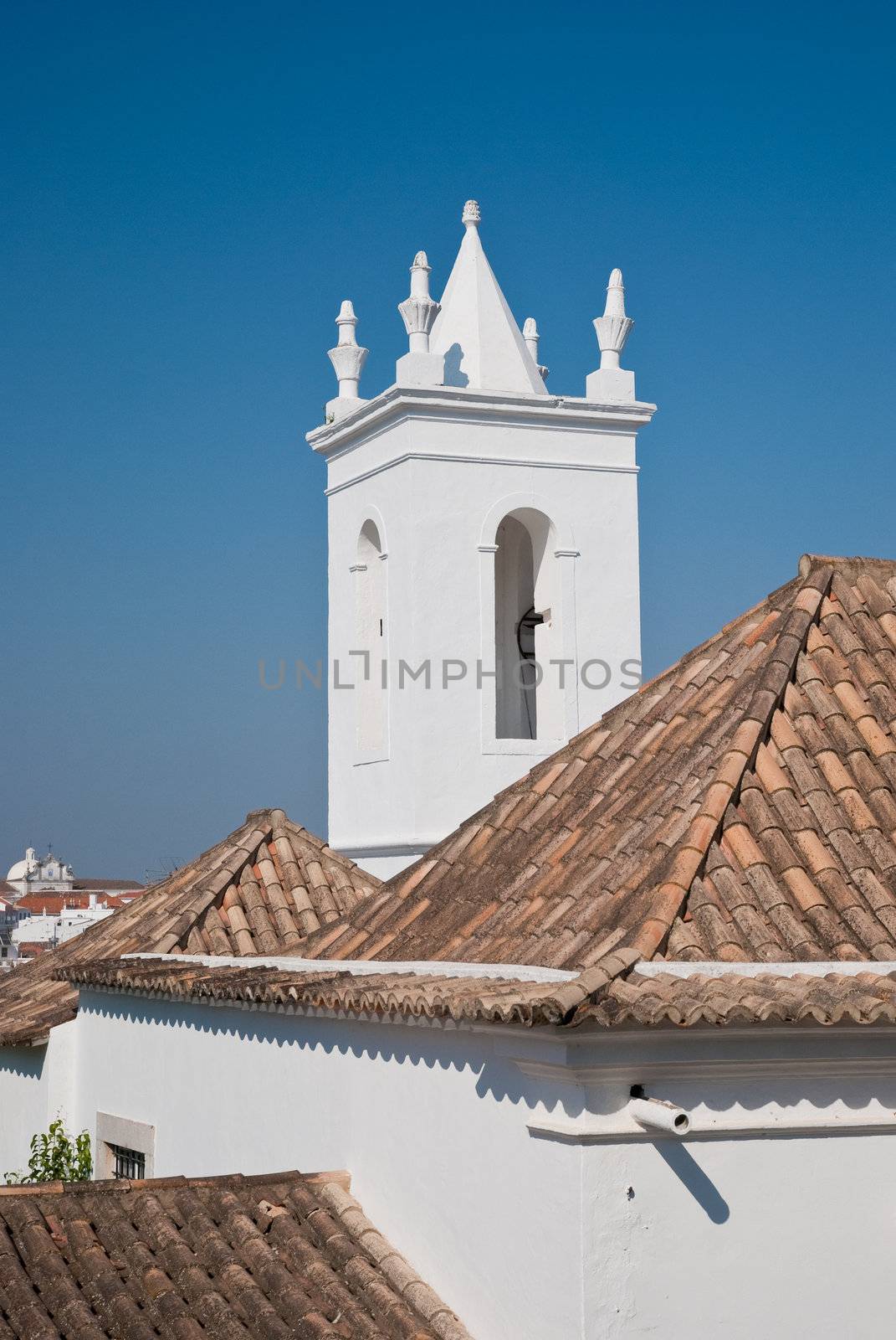 Tower Church and roofs against clear blue sky.