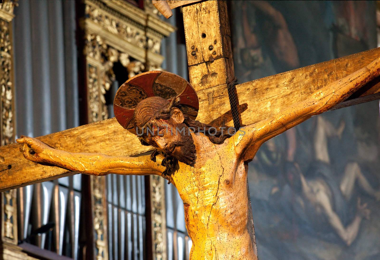 Ancient cross and Jesus statue in Salo Cathedral on banks of Lake Garda