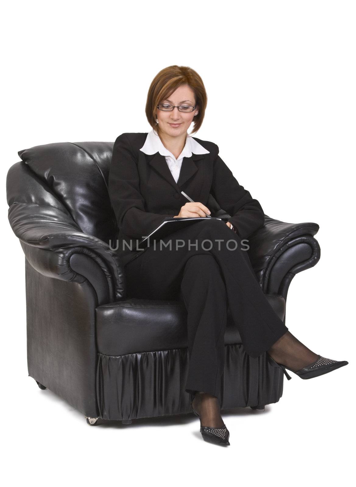 Businesswoman sitting in an armchair and writing something on a wallet.