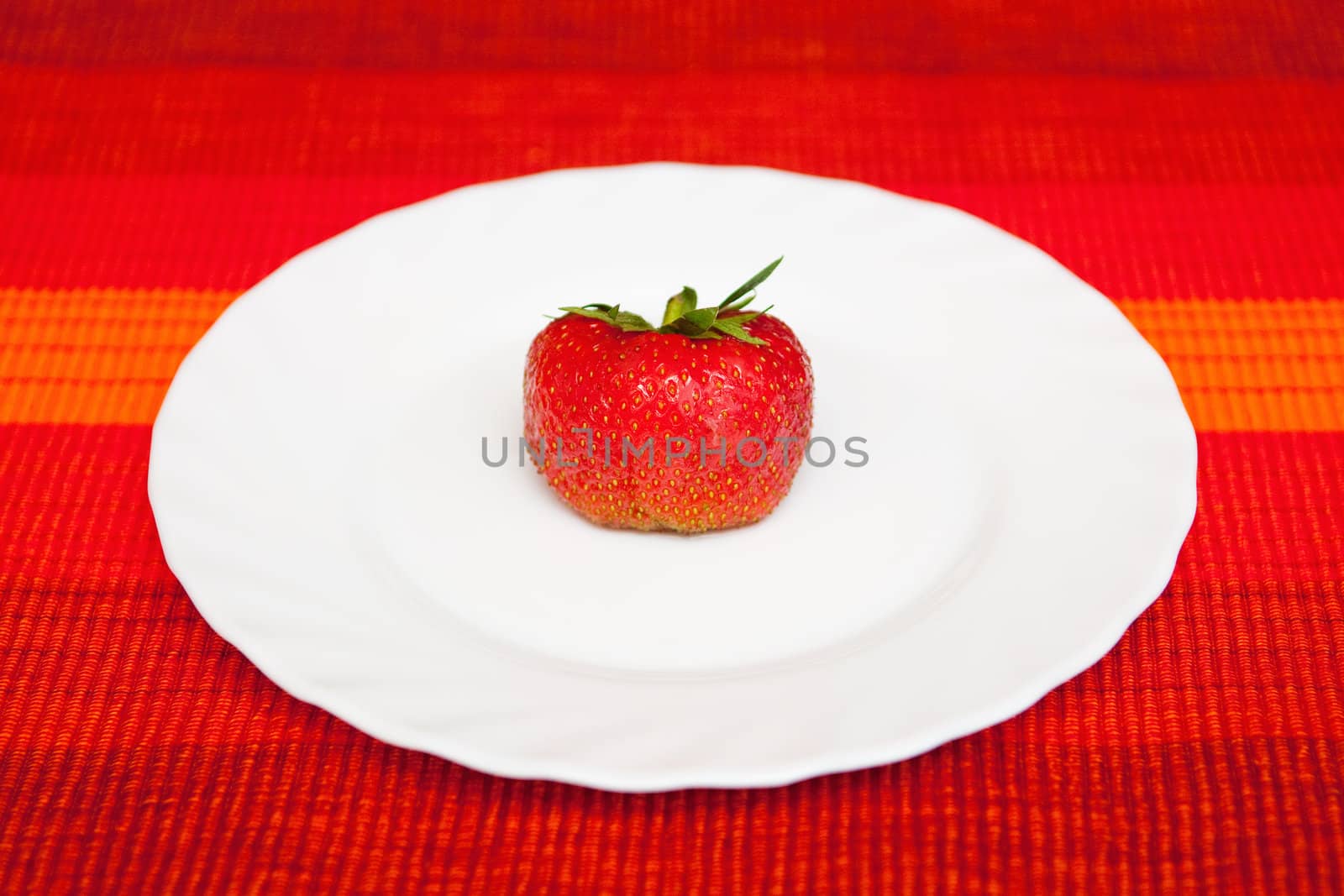 A fresh strawberry on the white plate
