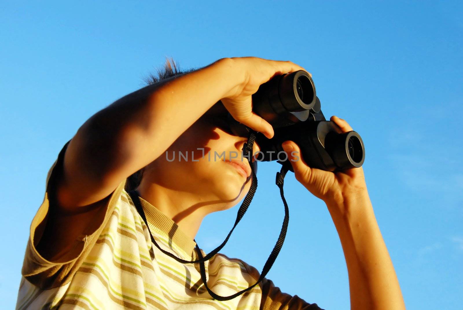 teen boy watching at black binoculars outdoor portrait