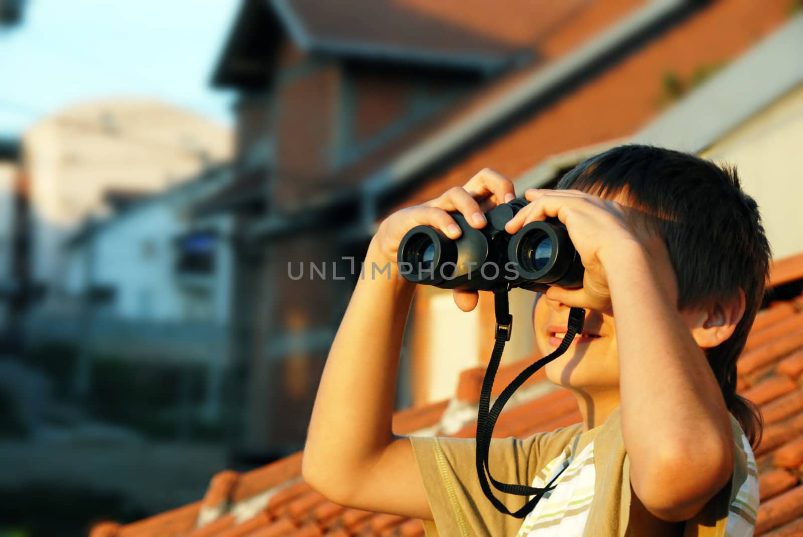 teen boy watching at black binoculars outdoor portrait