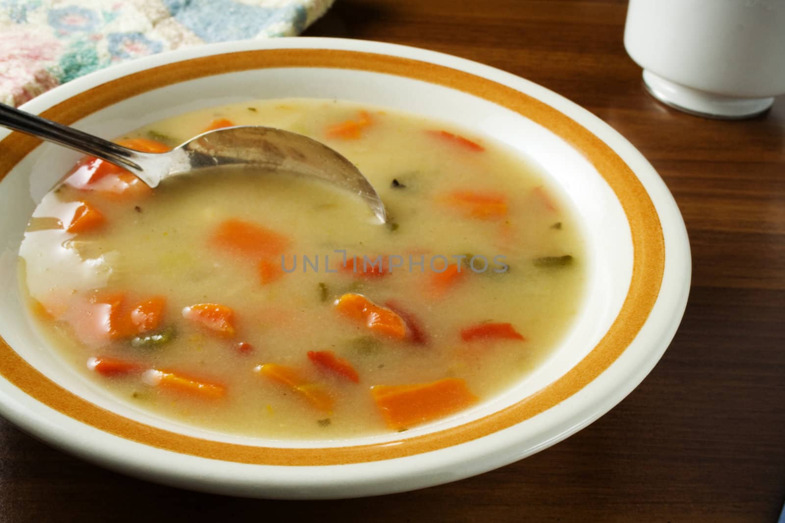 Vegetable chicken soup in bowl with spoon