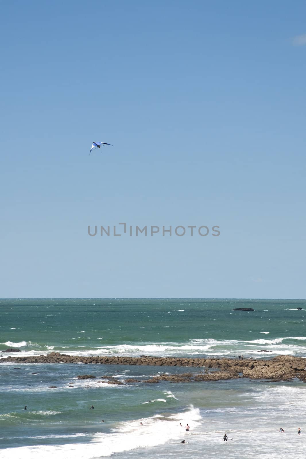 Blue and white kite in a blue sky above french Atlantic coast