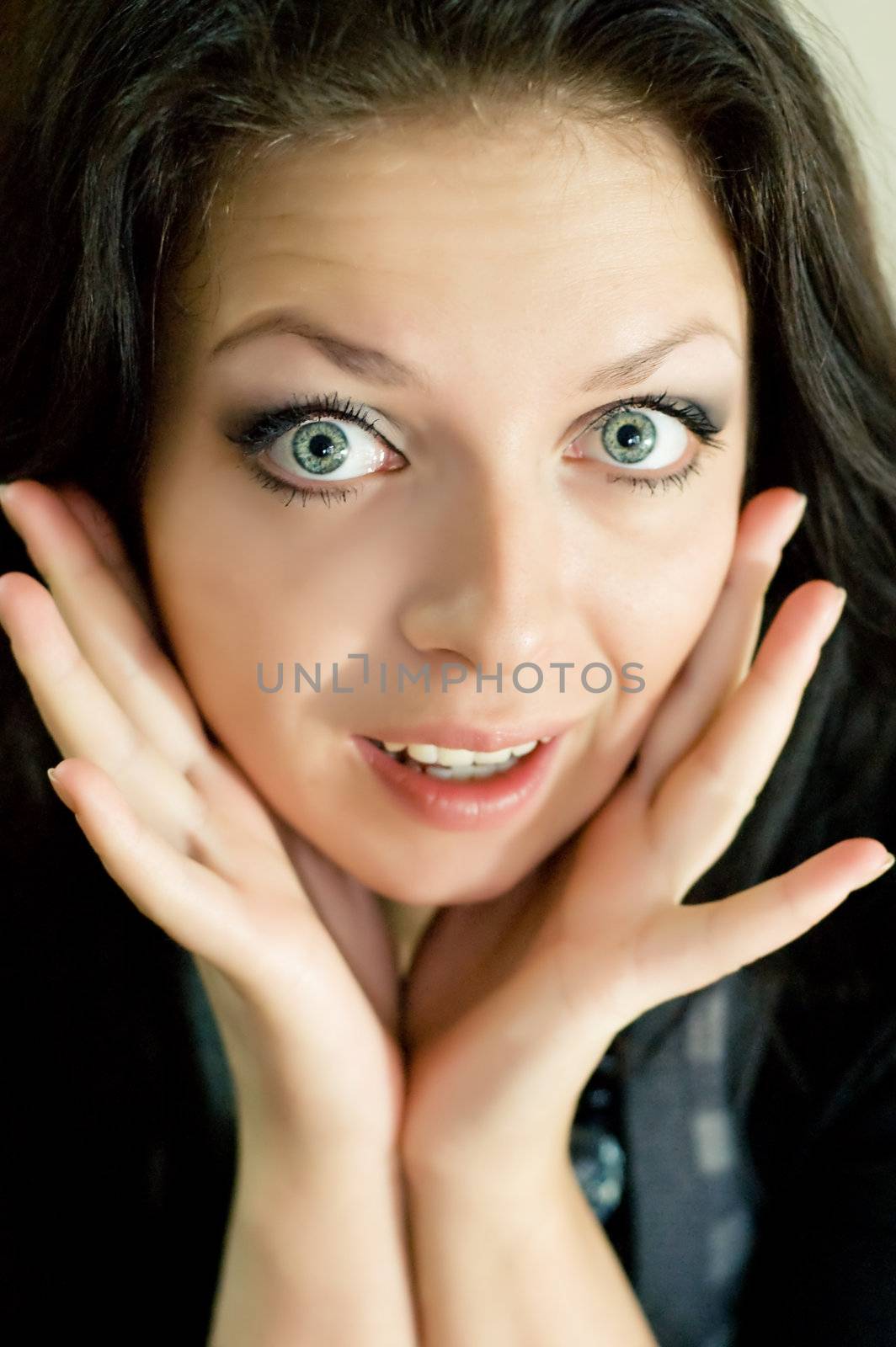 Portrait of a young confused woman with hands up